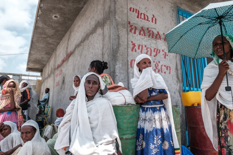 Women wait during a food distribution organised by the Amhara government