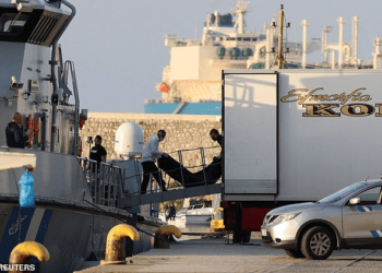 “Floating Coffins”: Meeting Death While Seeking A Future Of Hope 2 Rescue workers carry bodies from a coast guard vessel to a refrigerated truck at the port in Kalamata town.