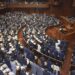 Japanese lawmakers stand as they approve a contentious awareness promotion bill for LGBTQ+ rights at the lower house in Tokyo Tuesday, June 13, 2023.