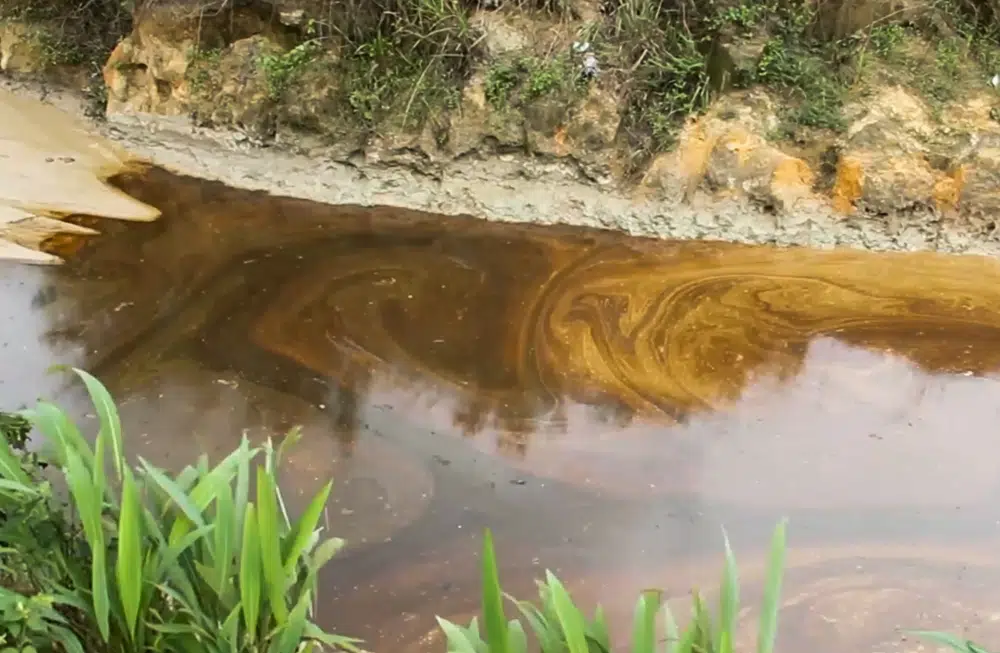 oil from a spill pollutes the Okuku river in Ogoniland Nigeria