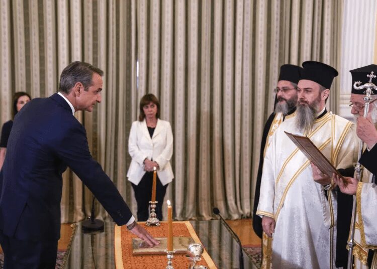 Greece's Prime Minister Kyriakos Mitsotakis, left, takes the oath during a swearing in ceremony at the Presidential palace, in Athens, Greece, Monday, June 26, 2023.