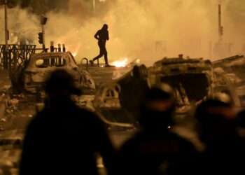 A demonstrator runs on the third night of protests sparked by the fatal police shooting of a 17-year-old driver in the Paris suburb of Nanterre, France.