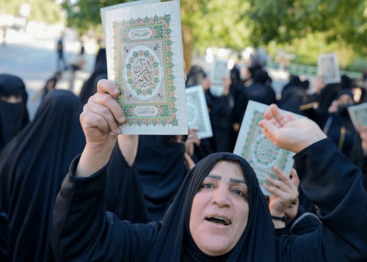 Iraqis raise copies of the Quran, Muslims' holy book, during a protest in Baghdad, Iraq, Saturday, July 22, 2023.