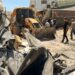 Palestinians walk on a damaged road in the Jenin Refugee Camp in the West Bank.