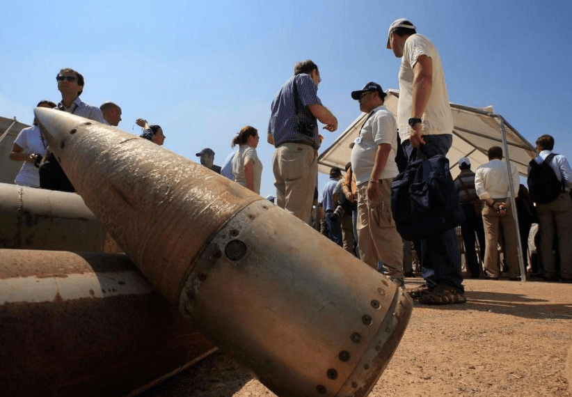 Activists and international delegations stand next to cluster bomb units, during a visit to a Lebanese military base at the opening of the Second Meeting of States Parties to the Convention on Cluster Munitions, in the southern town of Nabatiyeh, Lebanon, Sept. 12, 2011.