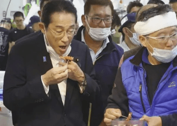 Japan's Prime Minister, Fumio Kishida tries seafood at the Toyosu fish market.