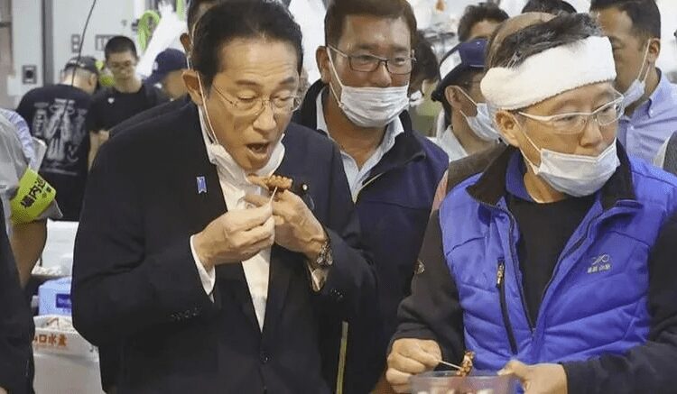 Kishida Pledges To Support Japan's Fishing Industry 1 Japan's Prime Minister, Fumio Kishida tries seafood at the Toyosu fish market.
