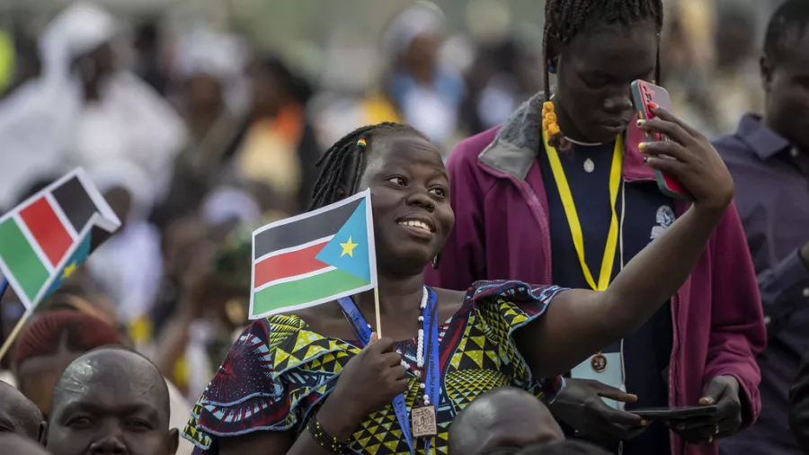 A woman takes a selfie holding a national flag South Sudan