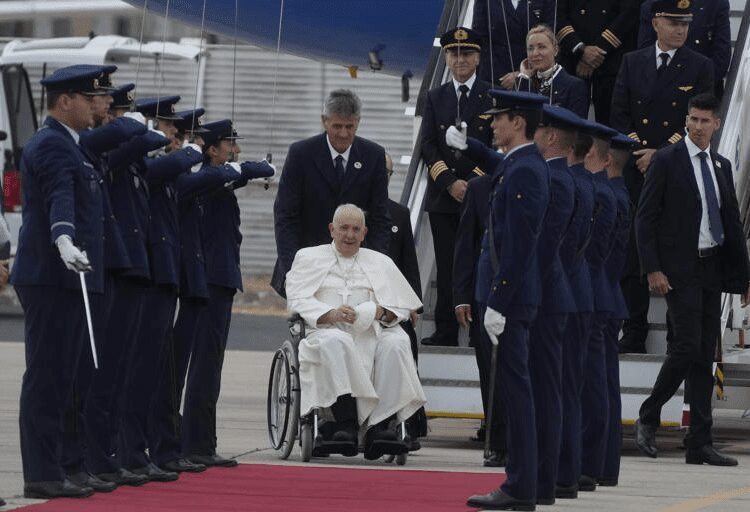 Pope Francis is welcomed by the honor guard as he arrives at the Figo Maduro airbase in Lisbon, Wednesday, Aug. 2, 2023.