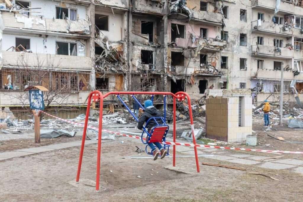 ukraine child swinging bombed building