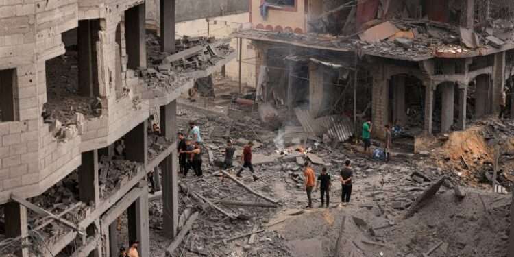 Palestinians inspect the destruction in a neighbourhood heavily damaged by Israeli airstrikes on Gaza City’s Shati refugee camp on Monday, October 9, 2023.