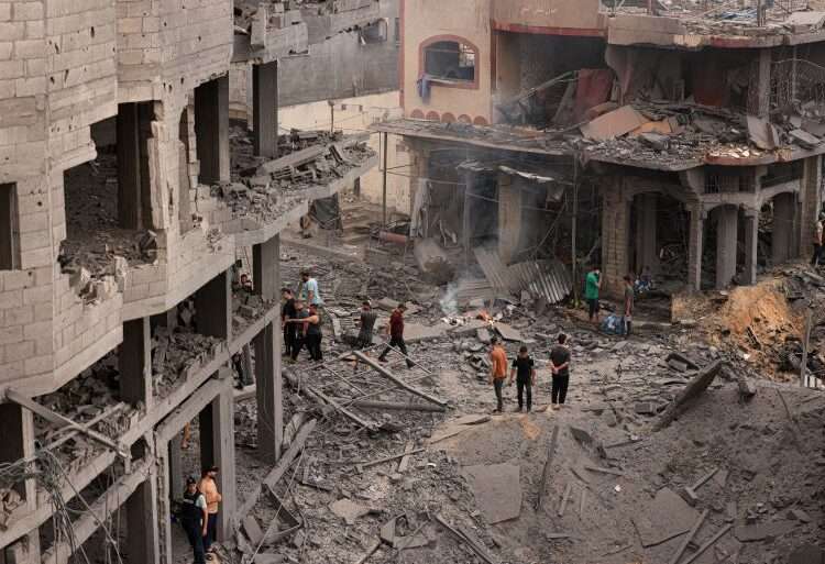 Palestinians inspect the destruction in a neighbourhood heavily damaged by Israeli airstrikes on Gaza City’s Shati refugee camp on Monday, October 9, 2023.