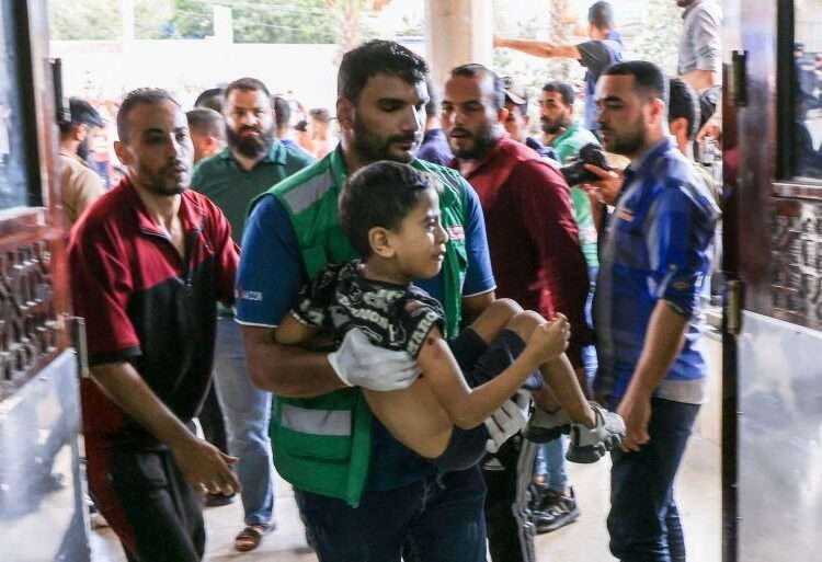 A medic carries a Palestinian child injured in Khan Younis in the southern Gaza Strip.
