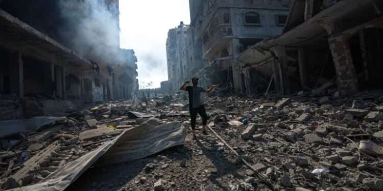 A Palestinian walks through the destruction by Israeli bombing in Gaza City.