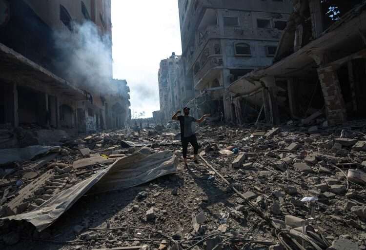 A Palestinian walks through the destruction by Israeli bombing in Gaza City.