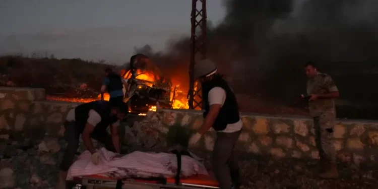 Civil defence workers remove the body of a journalist killed by Israeli shelling at Alma al-Shaab, a village in southern Lebanon on the border with Israel.