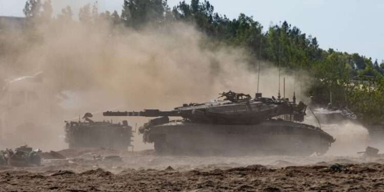Tanks move through the sand in Be’eri, Israel.
