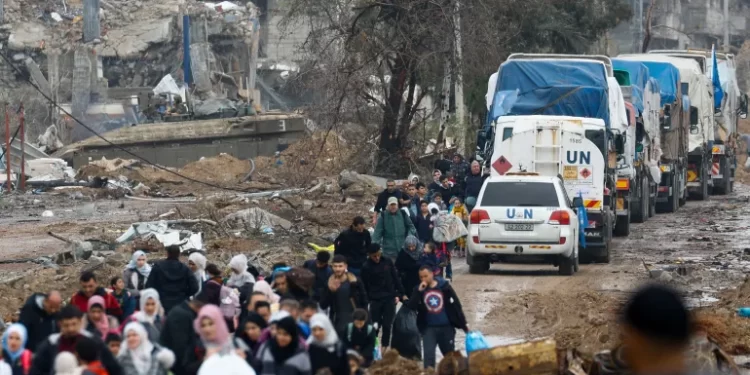 Palestinians fleeing north Gaza move southward as trucks carrying aid and fuel head towards north Gaza during a temporary truce between Israel and Hamas, near Gaza City.