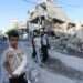 Palestinians walk by buildings destroyed in the Israeli bombardment of the Gaza Strip in Rafah, Tuesday.