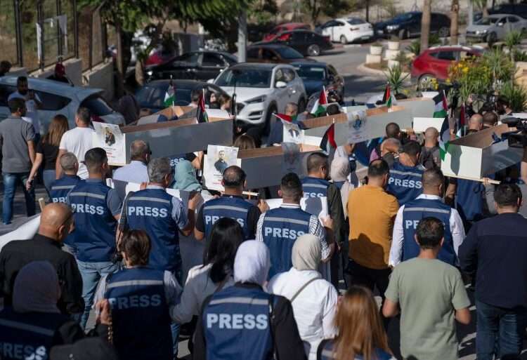 Palestinian journalists carry mock coffins of journalists who were killed during the current war in Gaza during a symbolic funeral toward a United Nations office in the occupied West Bank city of Ramallah.