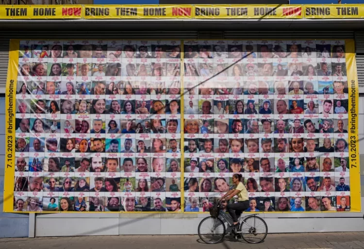 Captives Left At The Mercy Of Concession Deadlock 1 A woman cycles next to a billboard calling for the return of hostages in Tel Aviv, Israel.