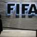 A FIFA employee walks past a sign of the FIFA at the headquarters on December 3, 2015 in Zurich.