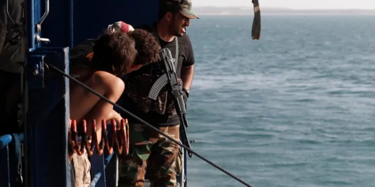 A fighter keeps watch on the deck of a cargo ship seized by the Houthis on December 5, 2023.