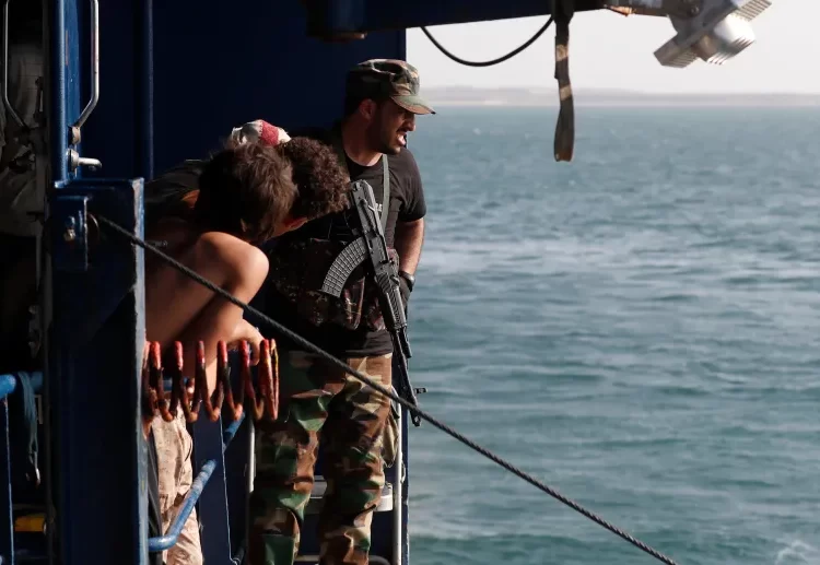 A fighter keeps watch on the deck of a cargo ship seized by the Houthis on December 5, 2023.