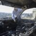 A Palestinian checks a car burned in an Israeli settler raid near Salfit.