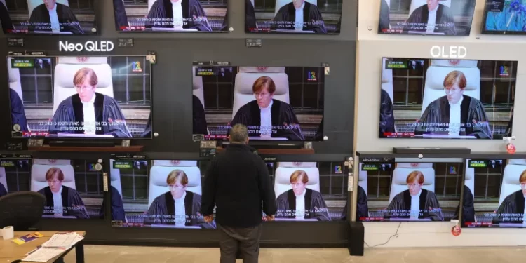 Israel Ordered To Take Steps To Prevent Acts Of Genocide In Gaza 1 Livestream from the International Court of Justice at a TV shop in Jerusalem.