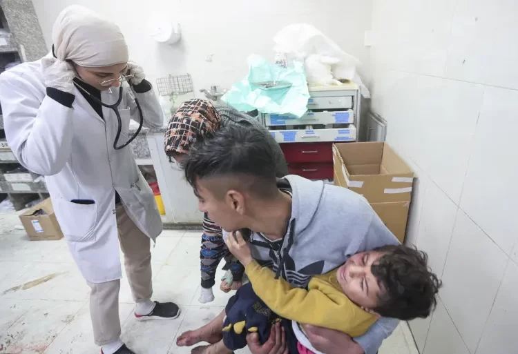 PNC Calls For Gaza Strip To Be Declared Disaster Zone 1 A Palestinian holds a child wounded in an Israeli strike at Nasser Hospital in Khan Younis, January 22, 2024.