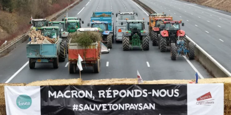 France Announce Measures To Ensure Fair Competition For Farmers 1 A banner reads 'Macron answer us' as French farmers block a highway with their tractors, in Longvilliers, near Paris, France.