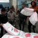 Palestinians carry bags of flour distributed by UNRWA in Rafah in the southern Gaza Strip on January 29, 2024.