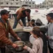 Volunteers distribute rations of red lentil soup to displaced Palestinians in the southern Gaza Strip on February 18, 2024.