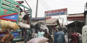 Workers offload grain from a truck at the MIle 12 Market in Lagos, Nigeria