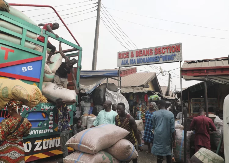 Workers offload grain from a truck at the MIle 12 Market in Lagos, Nigeria