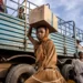Sudanese girl carrying a box