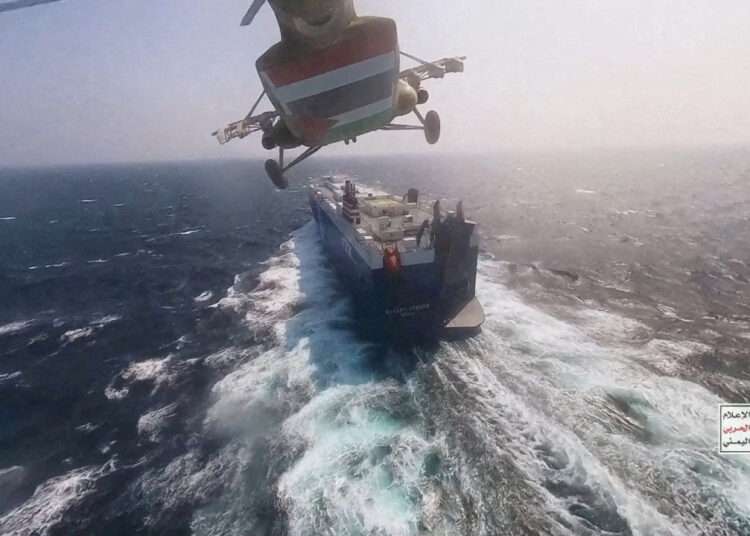 Houthi Attacks In Red Sea Severely Disrupt Aid Flow To Sudan 1 Houthi military helicopter flies over the Galaxy Leader cargo ship in the Red Sea