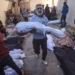 A man carries the body of a child killed by an Israeli air strike in Al Nusairat refugee camp.