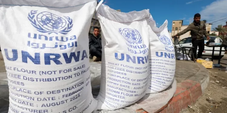 Israel Restriction Of Aid Entry To Constitute War Crime 1 Displaced Palestinians wait to receive United Nations Relief and Works Agency (UNRWA) aid, amid the continuing conflict in Rafah, in the southern Gaza Strip, on March 7, 2024.