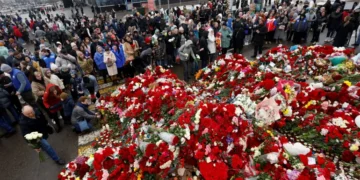 People gather at a makeshift memorial for the victims of a shooting attack set up outside the Crocus City Hall concert venue in the Moscow Region, Russia.