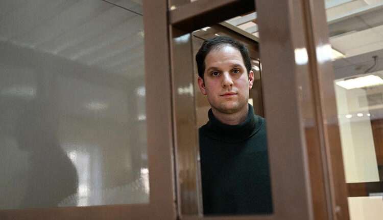 Evan Gershkovich, arrested on espionage charges, looks out from inside a defendants' cage before a hearing to consider an appeal to his extended pre-trial detention, at the Moscow City Court in Moscow on Feb. 20, 2024.