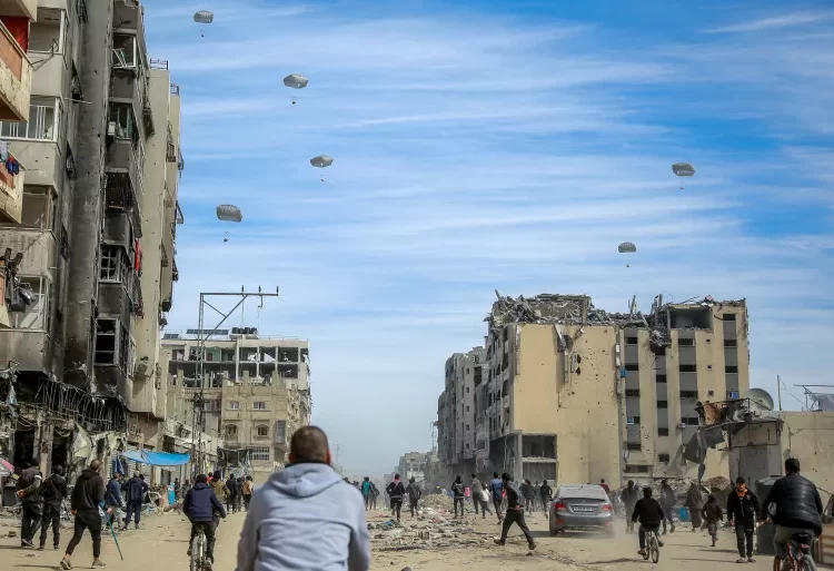 U.S Failing To Use Leverage To Assuage Gaza’s Woes 1 Palestinians run along a street as humanitarian aid is airdropped in Gaza City on Friday.