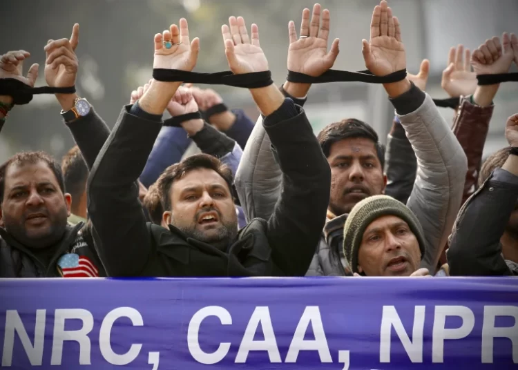India To Implement Controversial Citizenship Amendment Act 1 Indians raise their tied hands and shout slogans during a protest against the Citizenship Amendment Act in New Delhi, India, Dec. 27, 2019.