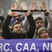 Indians raise their tied hands and shout slogans during a protest against the Citizenship Amendment Act in New Delhi, India, Dec. 27, 2019.