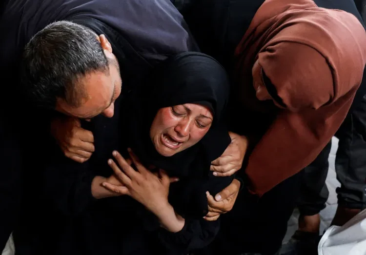 Unearthed Witnesses Of Torture Lost To Ravages Of Decomposition 1 A woman reacts next to the bodies of relatives killed in Israeli attacks in Rafah.