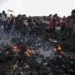 Palestinians observe the destruction caused by an Israeli attack on tents of displaced Palestinians living near UNRWA warehouses in Rafah.