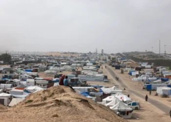 Displaced Palestinian children sit on a dune overlooking their tent camp in Rafah in the southern Gaza.