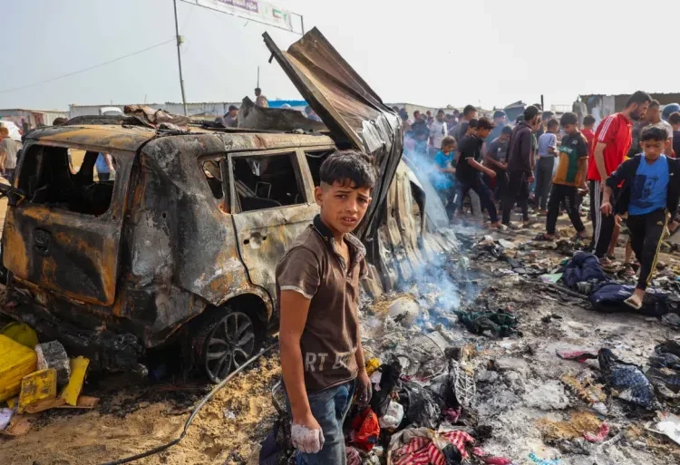 Israeli Airstrike On Rafah Likely To Hinder Mediation Efforts 1 Palestinians gather at the site of an Israeli attack on a camp area housing internally displaced people in Rafah on May 27, 2024.