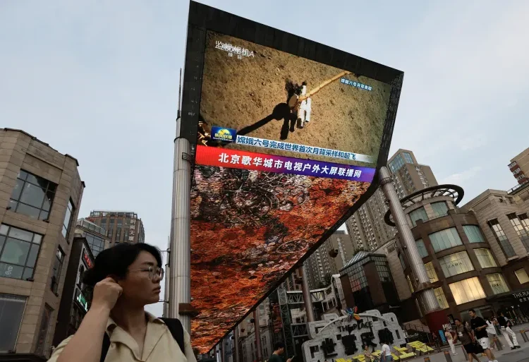 Chang’e-6 Lunar Probe Returns From Far Side Of The Moon 1 A large screen shows news footage of China's Chang'e-6 lunar probe collecting a sample from the far side of the moon, in Beijing, China, on June 4, 2024.